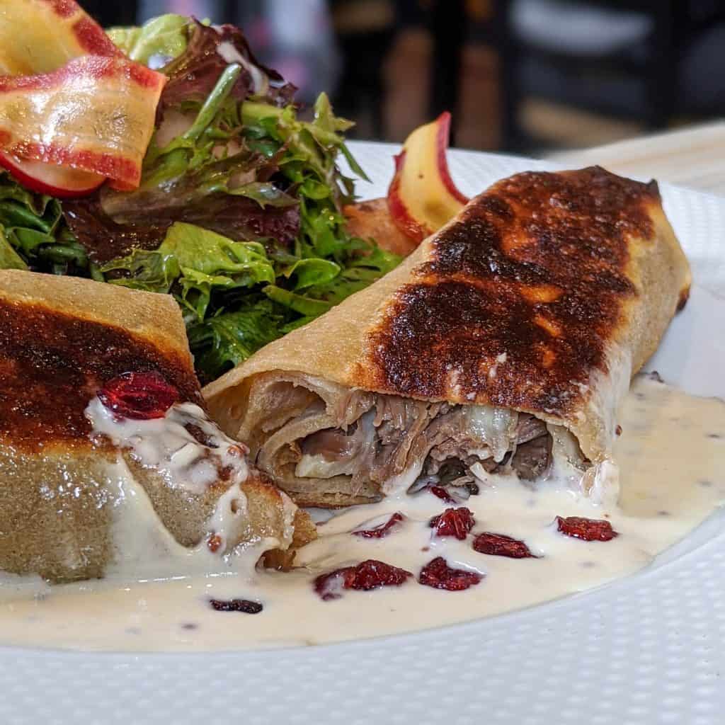 Spelled pancake stuffed with candied duck, Migneron de Charlevoix, caramelized onion and cranberry, hash brown, salad